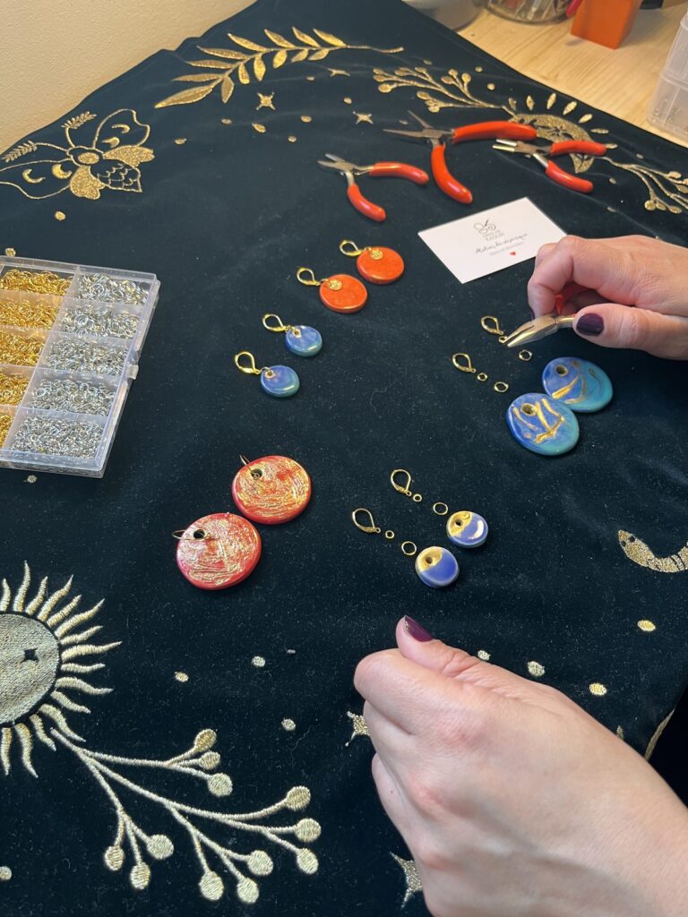 Mains assemblant des boucles d'oreilles en céramique